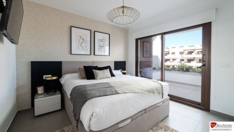 Bedroom in a 2-room apartment with a large window, art on the wall, and a comfortable bed.