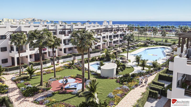 Palms, pool, and gardens in Pulpí holiday apartments with sea views.
