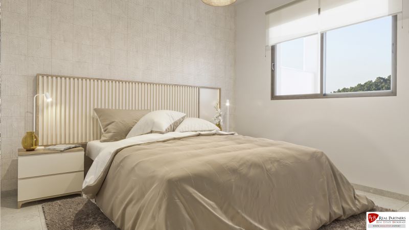 Bedroom in a holiday apartment with a bed, patterned wall, and large window.