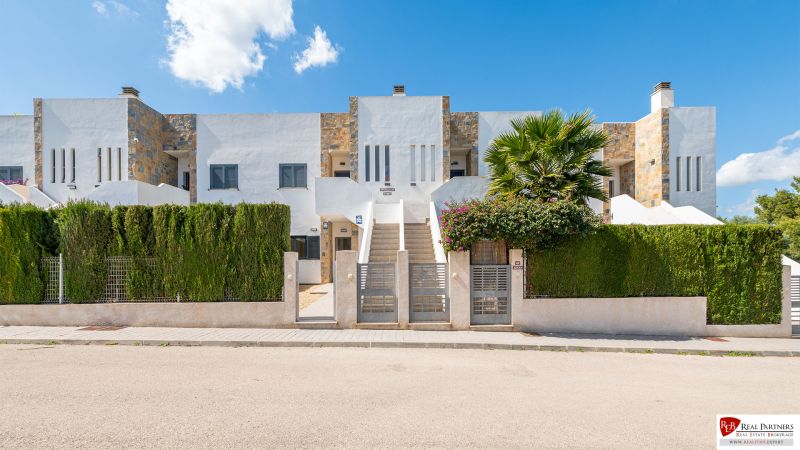 A recreational apartment in Cala Murada on Mallorca with a modern facade and a green fence.
