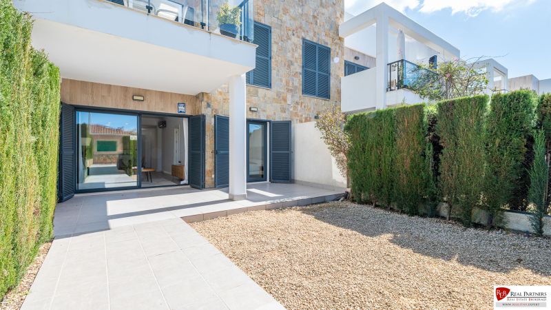 Holiday apartment in Cala Murada Mallorca with a terrace, stone walls, and a garden.