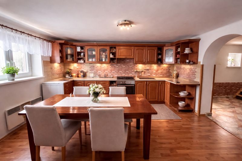A kitchen in a family house with a dining table and a wooden decor floor.