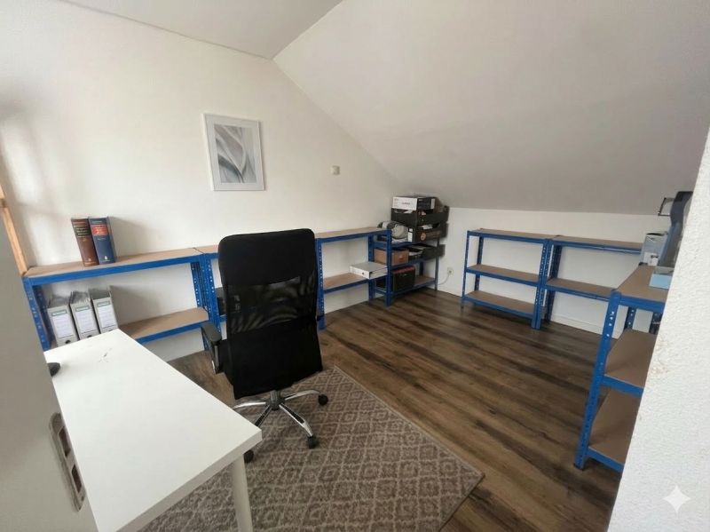 Office in a family house with a wooden decor floor, shelving system, and desk.