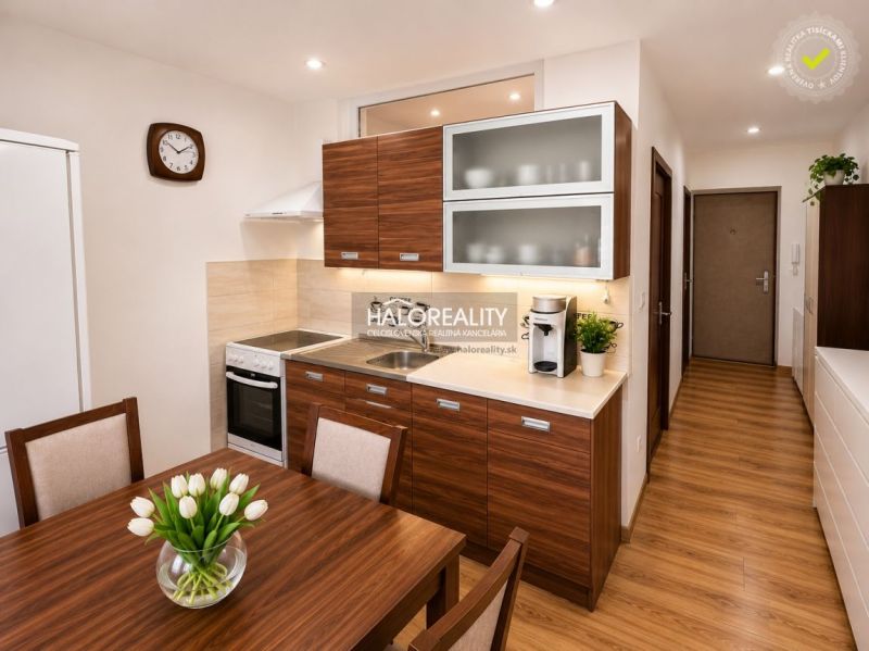 A kitchen in a one-room apartment with a wooden decor and simple furnishings.