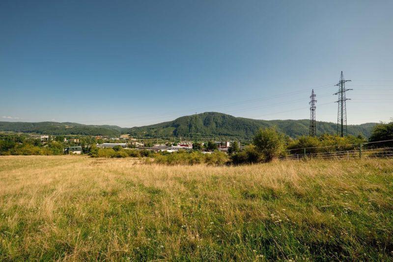 A landscape with a grassy plot and electric poles on Partizánska Street, Banská Bystrica. Plots - residential.
