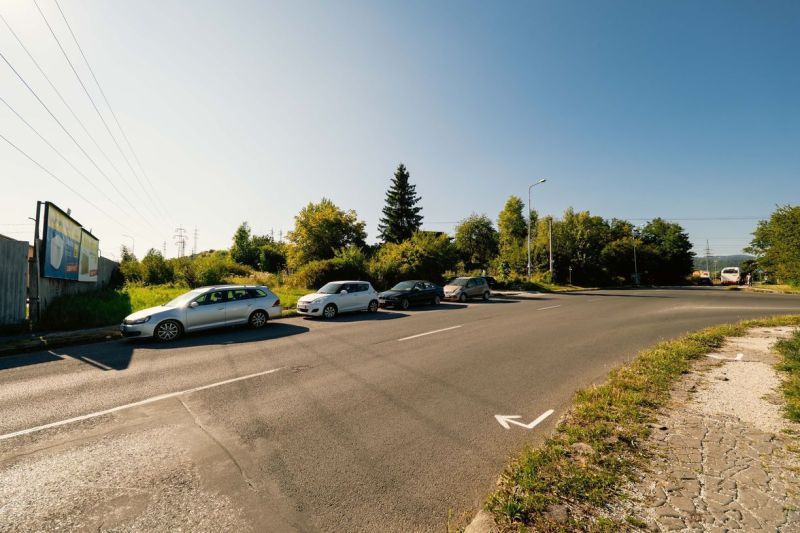 Road with parked cars and a billboard on Partizánska Street, Banská Bystrica, Land - housing.
