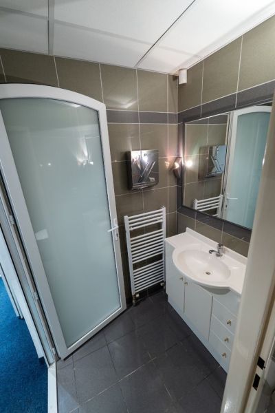 Bathroom with a shower, sink, mirror, and ladder radiator in Unusual Properties.