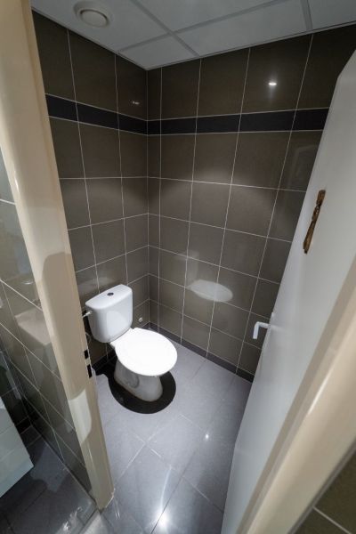 Bathroom with gray tiles and a toilet in Unusual Properties.