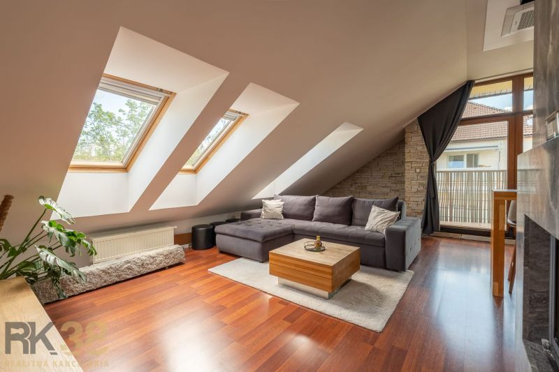 Living room in a three-room apartment with a wooden decor floor and skylights.