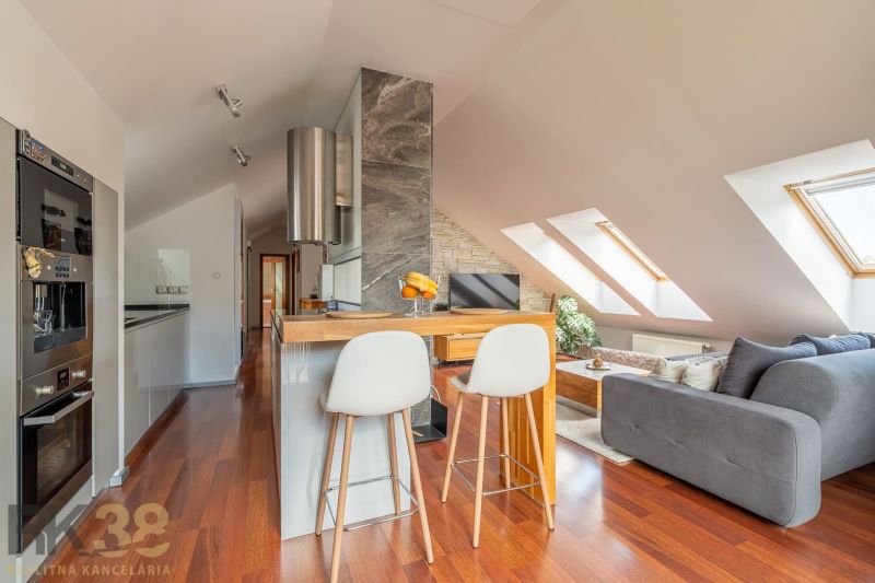 Attic 3-room apartment with a kitchen island, wood-patterned flooring, and skylights.