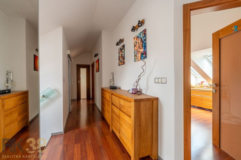A hallway in a 3-room apartment with dressers and decorations, floor with wood decor.