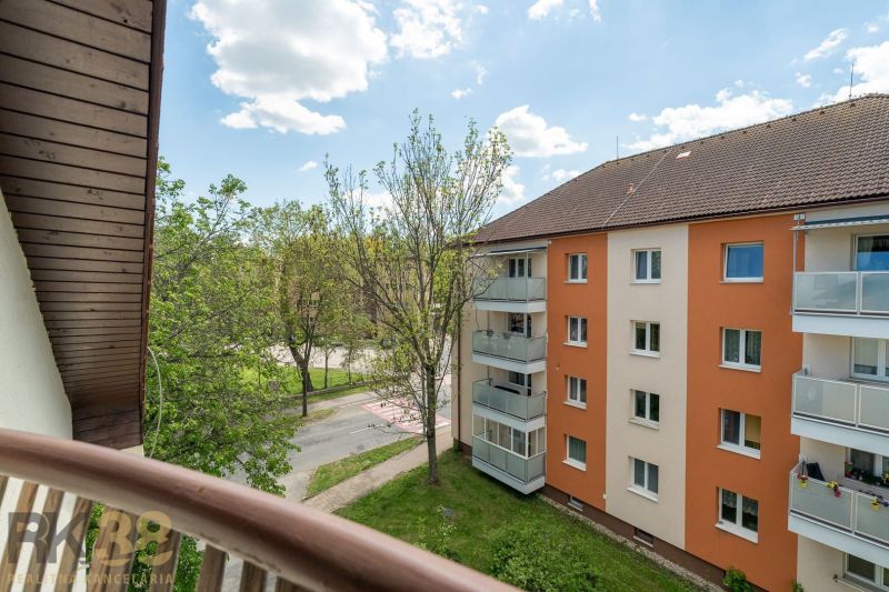 View from the balcony of a 3-room apartment in Poprad to the surrounding greenery and residential building.