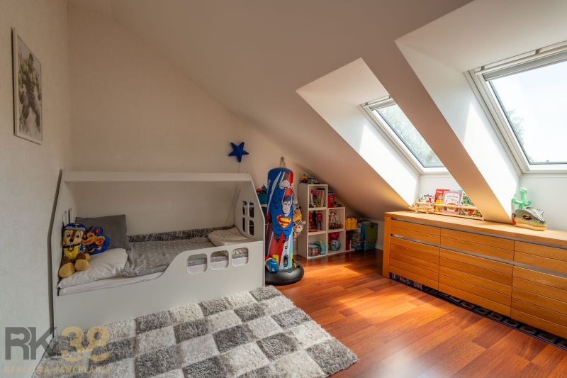 Children's room in a 3-room apartment with a wooden decor floor and slanted skylights.