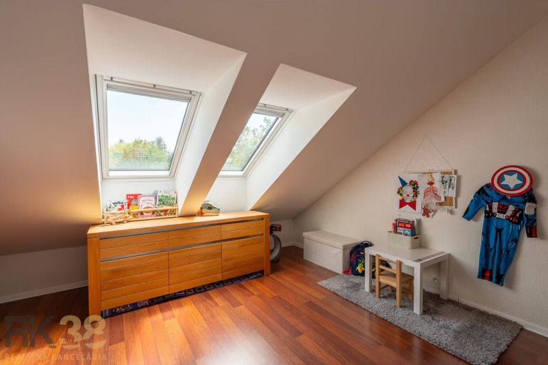 Children's room in a 3-room apartment with slanted windows and a wooden decor floor.