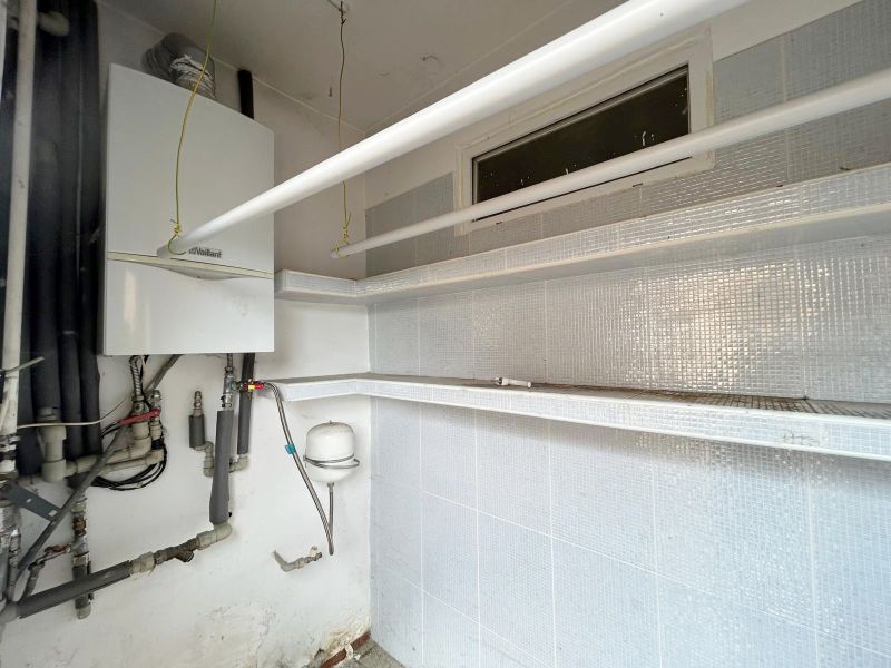 Boiler room in a family house, with a gas boiler and piping.