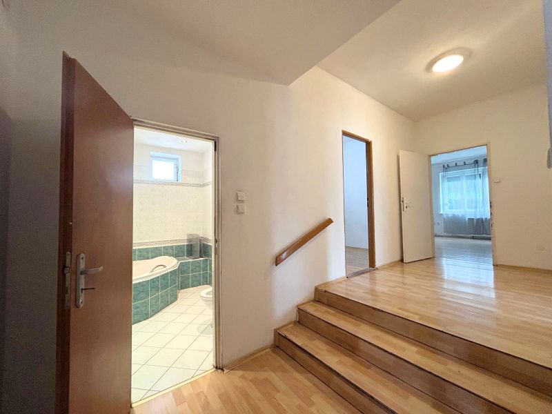 A staircase with a wooden floor leading to the bathroom in a family house.