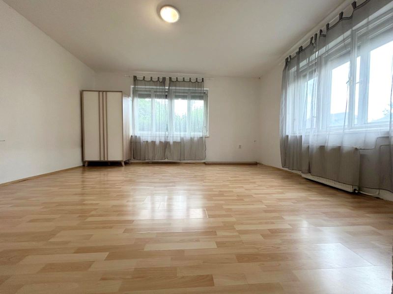 Interior of a family house with a wooden decor floor and two windows.
