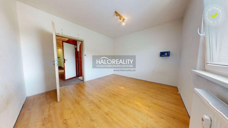 A bright room with a wood-patterned floor in a three-room apartment.