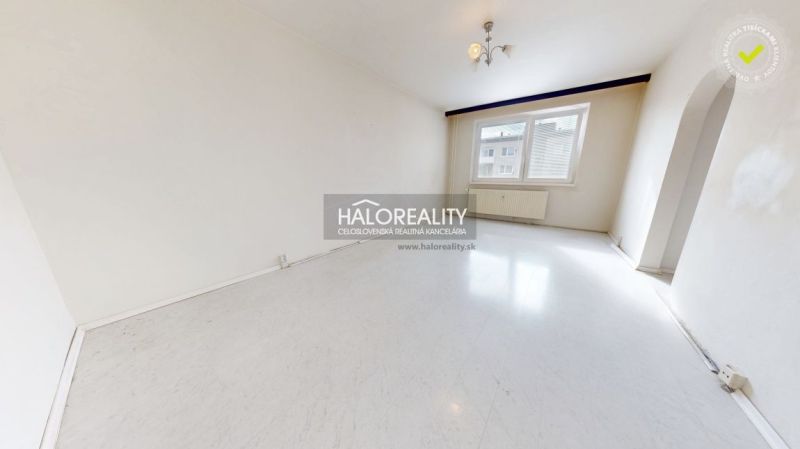 A spacious room with a white floor in a 3-room apartment, bright walls and a window.