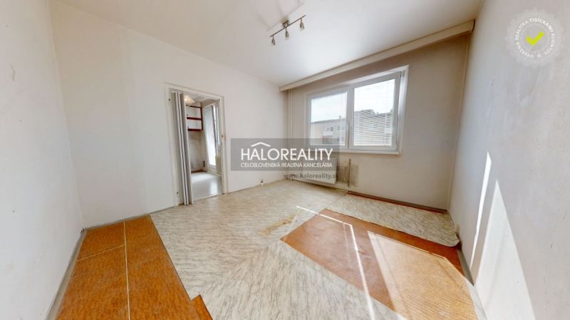 A room in a 3-room apartment with a window, wooden decor flooring, empty room.