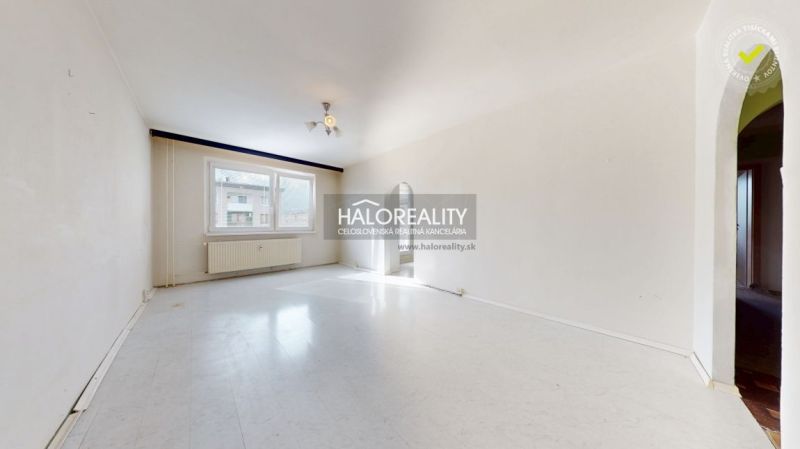 A spacious room with a large window in a 3-room apartment, floor with wooden decor.