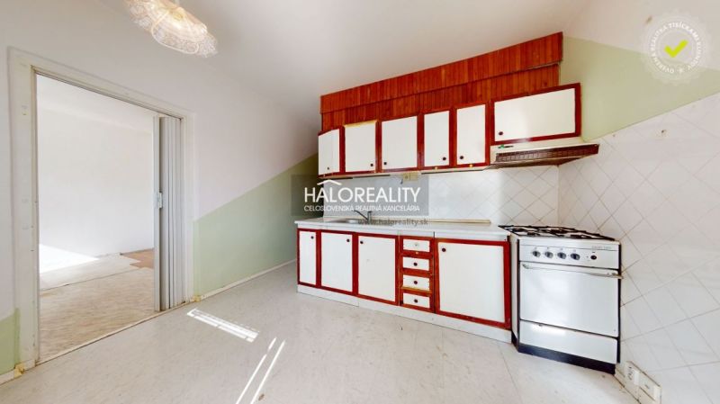 A kitchen with a stove and cabinets in a 3-room apartment, flooring with a floor decor.