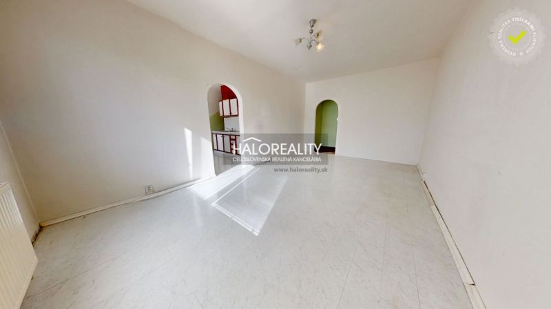 A spacious room in a 3-room apartment with a white floor and arched doorways.