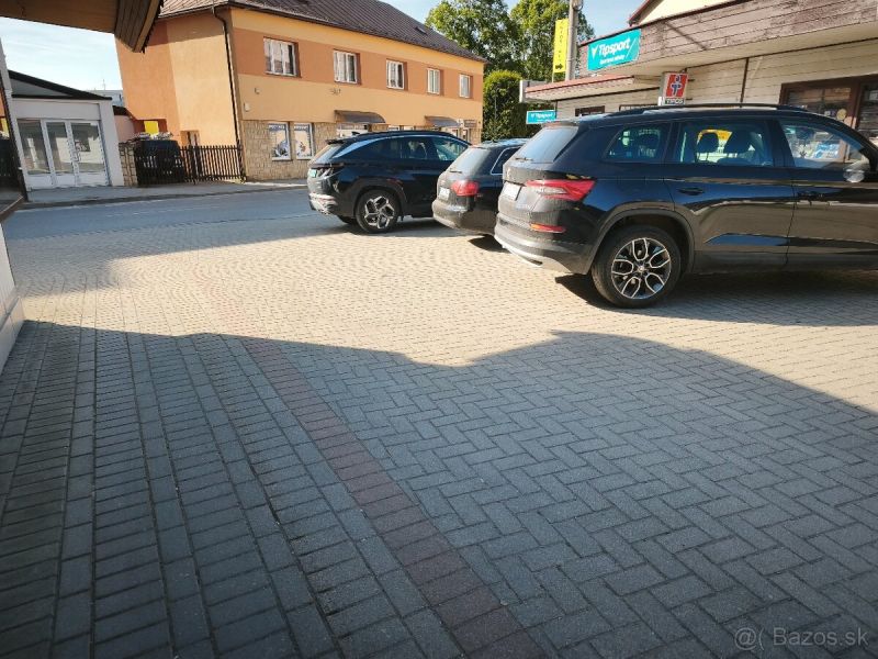 Parking lot at commercial premises in Turzovka with cars on the pavement.