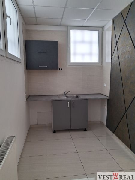 Offices with a kitchenette, tiled flooring, and a gray cabinet, suitable for a work environment.