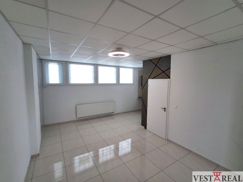 Offices with light tiles, white walls and windows, simple ceiling design.