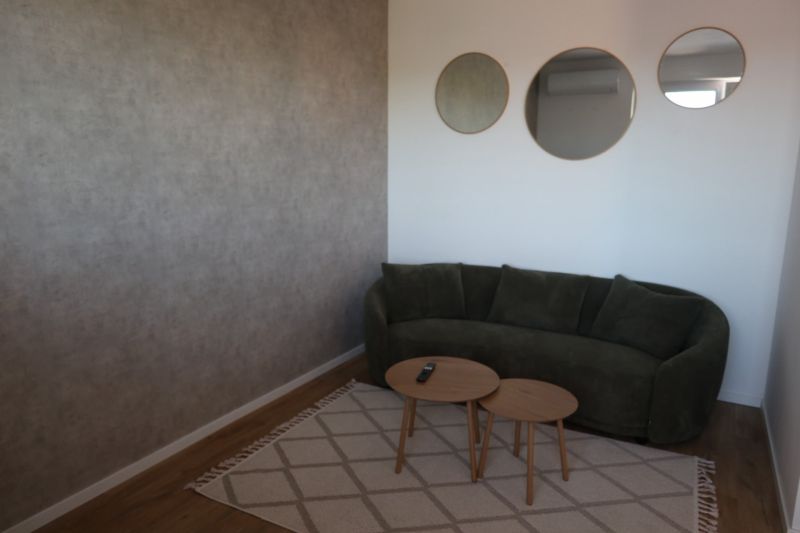 A sofa and a coffee table in a 2-room apartment, a carpet and a floor with a wooden decor.
