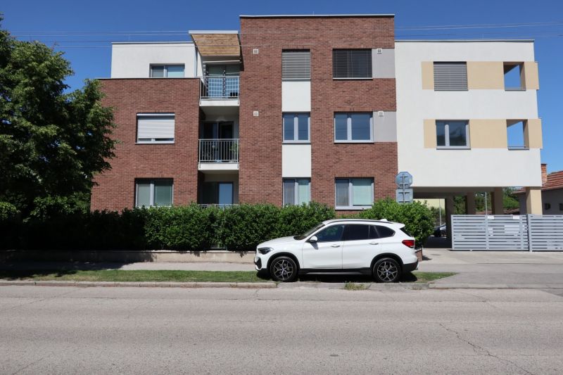 An apartment building on Štefánikova Street in Dunajská Streda with a white car in the foreground.
