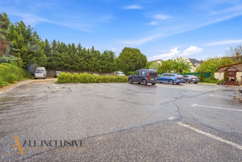 A parking lot in Nitra surrounded by greenery and cars in the Gastro premises.