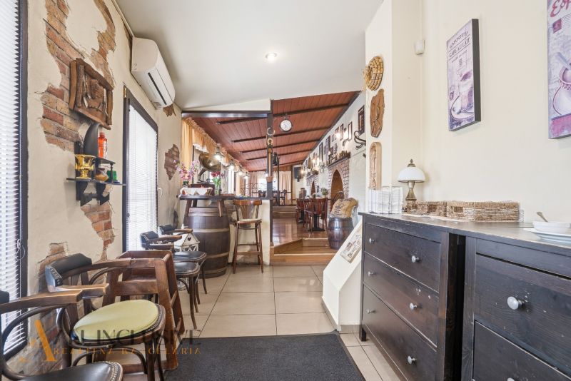 Interior of gastro spaces with decorations, a brick wall, and cozy wooden furniture.