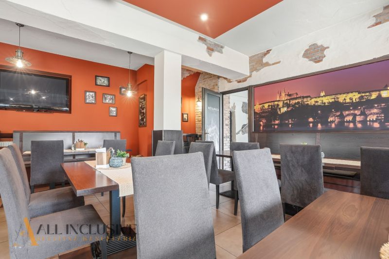 Interior of dining spaces with orange walls and gray chairs, accentuated by decorative elements.