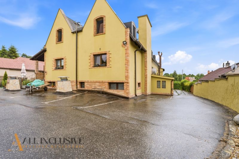 In front of the building in Nitra with gastro premises, there is a parking lot and a terrace.
