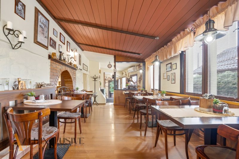 Gastro premises with wooden decor flooring, tables, and wall decorations.