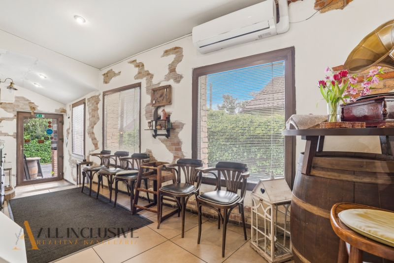 Interior of gastro spaces with bar stools, a decorative gramophone, and flowers on the table.