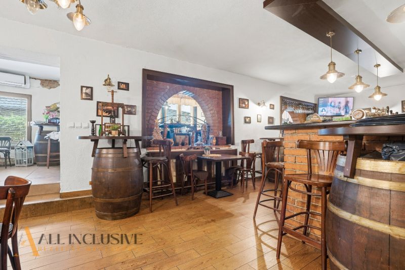 Interior of a gastro space with brick cladding, wooden barrels, and a floor with a wooden decor.