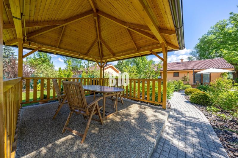 A wooden gazebo with seating in the garden of a family house in Bíková Humence.