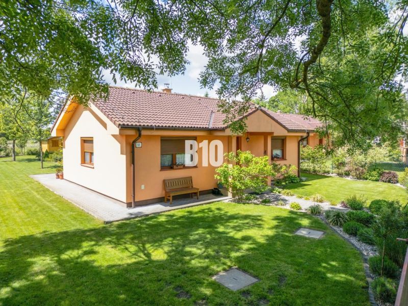 A family house in Bíľkovy Humence surrounded by a well-maintained garden and green lawn.