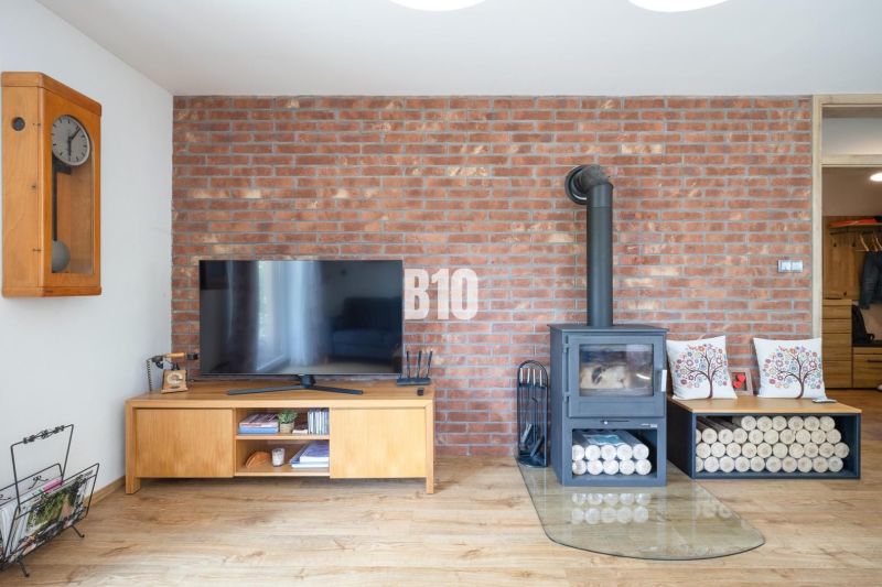 Television and fireplace on a brick wall, floor with wood decor, family house.