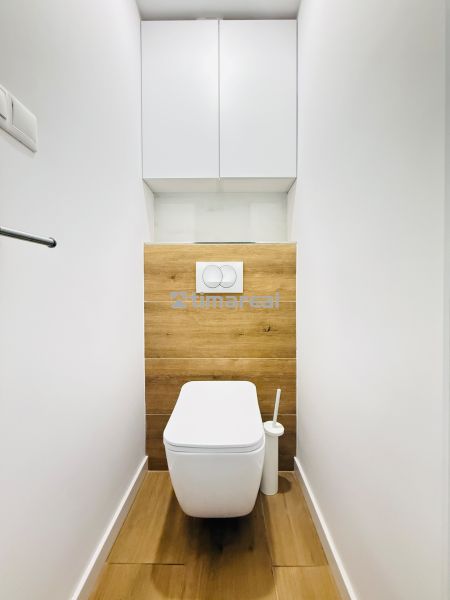 A bathroom in a 3-room apartment with flooring and tiles featuring a wood design.
