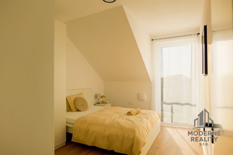 A bright bedroom in a family house with white walls and a floor with a wooden decor.