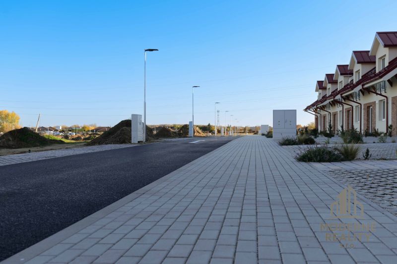 Street in front of family houses in Andovce, next to the new asphalt road and sidewalks.