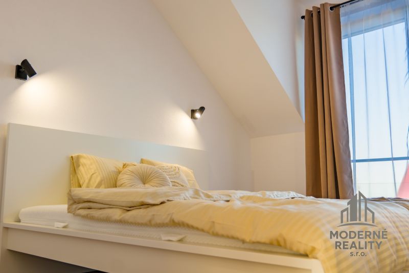 A bedroom in a family house with a comfortable bed and delicate curtains.