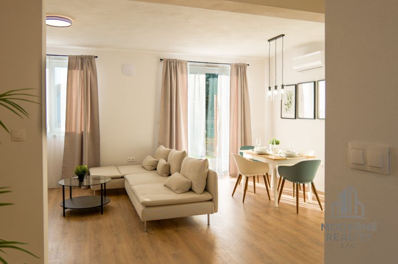 Interior of a family house with a sofa, dining table, and wooden decor flooring.