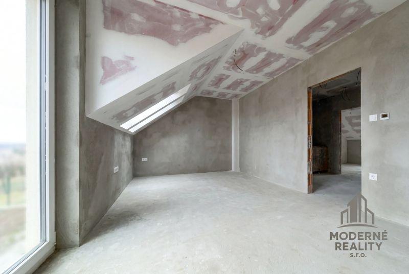 An attic room with an unfinished drywall ceiling construction in a family house.