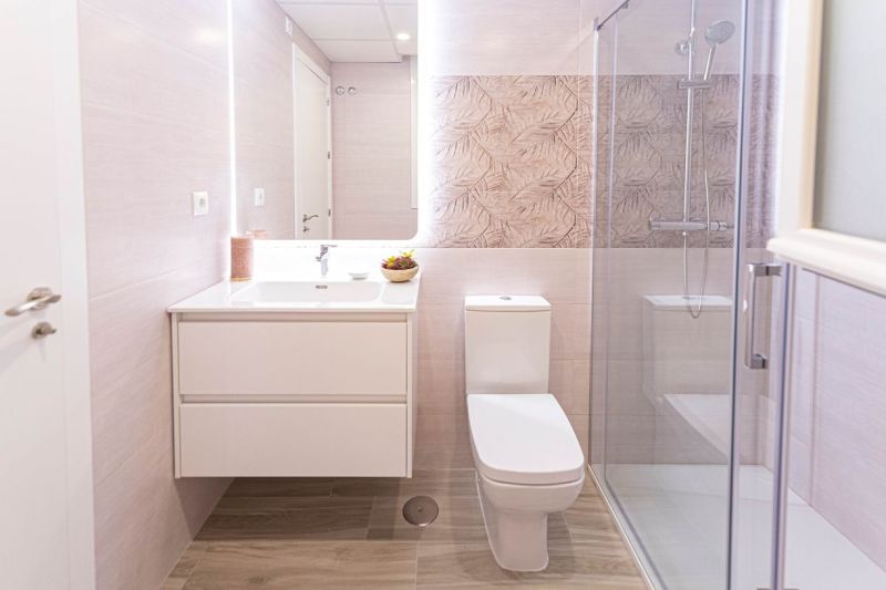 Bathroom in a holiday apartment with a wooden decor floor and a shower corner.