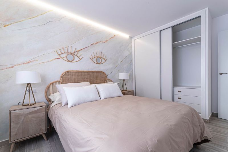 A recreational apartment with decorative elements, a double bed, and a wooden decor floor.